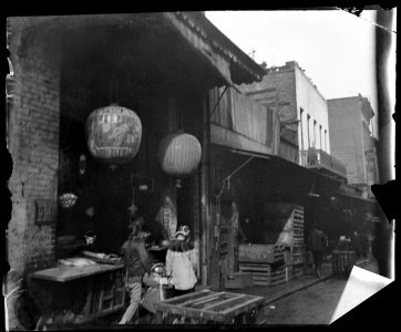 Two women and a child walking down a sidewalk betwen crates, Chinatown, San Francisco LOC agc.7a09031