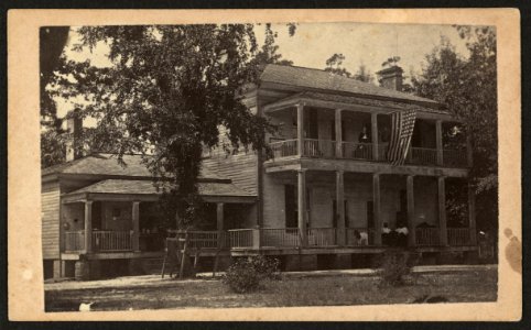 Two-story building with U.S. flag flying from second floor, possibly used as Freedmen's quarters) - J. D. Heywoods photographic rooms, Craven St., 3d door South PO, New Berne, N.C LCCN2010647739
