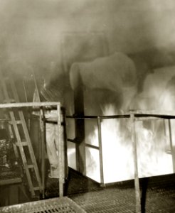 U.S Navy sailor at firefighting school near fire set for training purposes on ship mock-up, 1943 (26349596402)