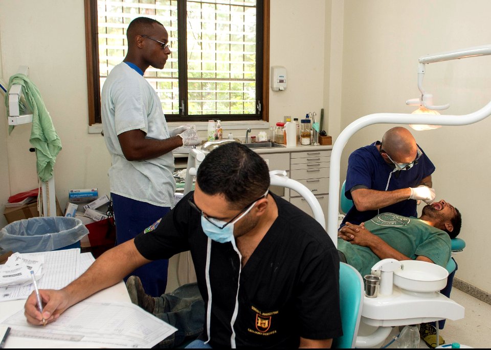 U.S. Army Maj. Michael Mansell and Sgt. Christopher Coleman, assigned to Southern Region Dental Command, and Dr. Sergio Juarez perform a dental procedure during Southern Partnership Station (SPS) 2014 in Puerto 140812-N-QY430-012