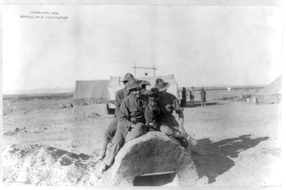 U.S. Army tent camp in Mexico, 1914- 3 soldiers sitting atop field oven with baby goat LCCN2003655563
