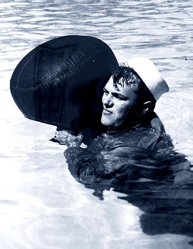 U.S. Coast Guardsman using inflated sea bag to stay afloat, WWII (26831786504)