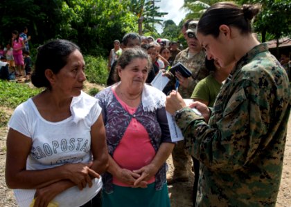 U.S. Marine Corps Capt. Annie Pittis, right, speaks to two Guatemalan patients at a medical civic action project (MEDCAP) in Puerto Barrios, Guatemala, Aug. 23, 2014, during Southern Partnership Station (SPS) 140823-N-QY430-062