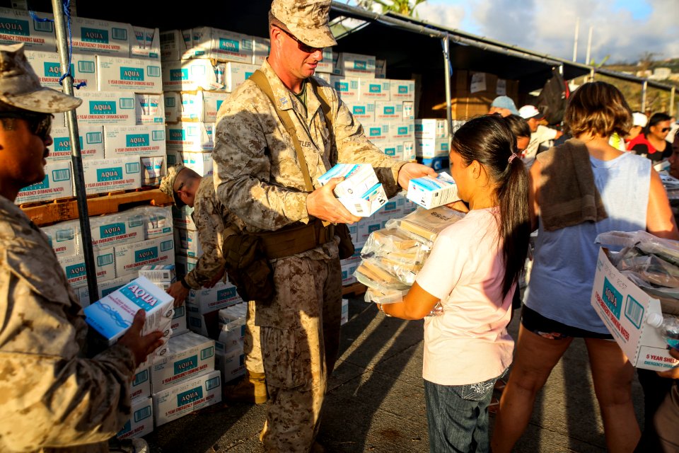 U.S. Marine Capt. Jeffery Butler distributes water at a shelter in Saipan. (20386137819)