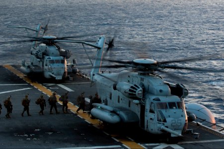 U.S. Marines assigned to the 31st Marine Expeditionary Unit (MEU) board a CH-53 Super Stallion helicopter attached to Marine Medium Tiltrotor Squadron (VMM) 265 on the flight deck of the amphibious assault ship 140310-N-LM312-034