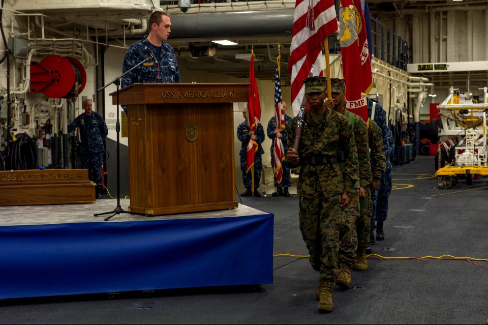 U.S. Marine Corps color guard members parade the colors during a 9-11 remembrance ceremony in the hangar bay aboard the newly commissioned amphibious assault ship USS America (LHA 6) Sept 140911-N-MD297-013