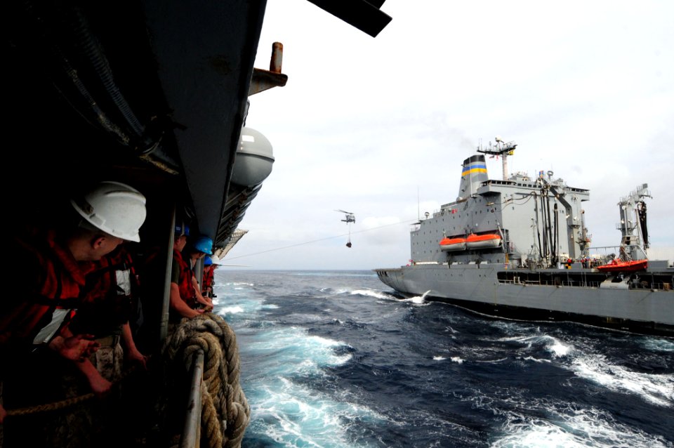 U.S. Marines aboard the dock landing ship USS Comstock (LSD 45) watch an MH-60S Seahawk helicopter transfer supplies during and underway replenishment with the fleet replenishment oiler USNS Rappahannock (T-AO 110317-N-RC734-454