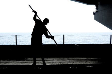 U.S. Naval Aircrewman (Tactical Helicopter) 2nd Class Matt Ballard stretches before a workout in the hangar bay aboard the aircraft carrier USS George H.W. Bush (CVN 77) in the Persian Gulf July 1, 2014 140701-N-MU440-012
