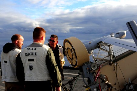 U.S. Marines with the 13th Marine Expeditionary Unit and Boeing employees with the Scan Eagle team, perform pre-flight checks on an Unmanned Aerial Vehicle (UAV) prior to launch from the flight deck aboard 110224-N-RC734-324