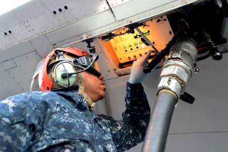 U.S. Navy Aviation Ordnanceman Airman Kevin Scott fuels a P-8A Poseidon aircraft before a mission in Perth, Australia, April 2, 2014 140402-N-VD564-002