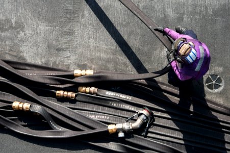 U.S. Navy Aviation Boatswain's Mate (Fuels) Airman Chelsey Fucito gathers a fuel hose on the flight deck of the aircraft carrier USS Harry S. Truman (CVN 75) in the Gulf of Oman Feb. 21, 2014 140221-N-ZG705-311