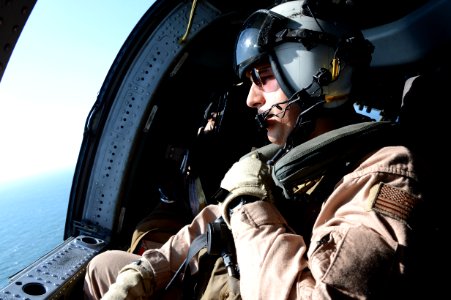 U.S. Navy Aviation Systems Warfare Operator 2nd Class Justin Colon, assigned to Helicopter Sea Combat Squadron (HSC) 26, talks to his crew aboard an MH-60S Seahawk helicopter while transiting above the Persian 131207-N-OU681-061 photo