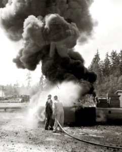 U.S. Navy firemen testing 60 gallon per minute hose with umbrella spray, 1943 (26375731501)