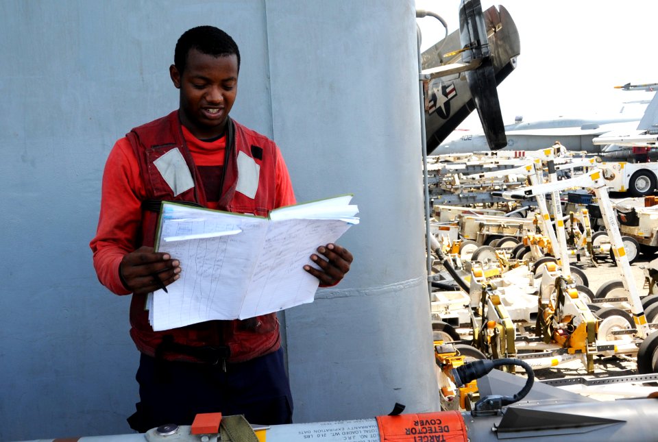 U.S. Navy Aviation Ordnanceman Airman Jeremy Brown checks an ordnance log aboard the aircraft carrier USS George H.W. Bush (CVN 77) in the Persian Gulf June 26, 2014 140626-N-MU440-024