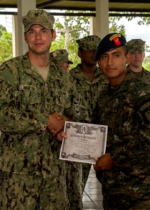 U.S. Navy Boatswain's Mate 3rd Class Zach Martin, left, attached to Coastal Riverine Squadron (CORIVRON) 2, gives a certificate to a Guatemalan service member as part of their closing ceremony in Puerto Barrios 140821-N-QY430-046