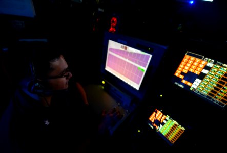 U.S. Navy Air Traffic Controller 2nd Class Michael Aguilera monitors air operations in the amphibious air traffic control center aboard the amphibious assault ship USS Bataan (LHD 5) March 23, 2014, in 140323-N-MW280-077
