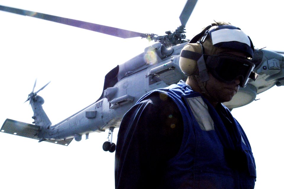 U.S. Navy Boatswain's Mate 3rd Class Cecil Dopel with an MH-60R Seahawk helicopter. June 18, 2013