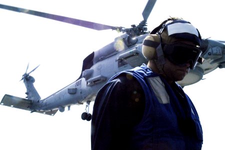 U.S. Navy Boatswain's Mate 3rd Class Cecil Dopel with an MH-60R Seahawk helicopter. June 18, 2013