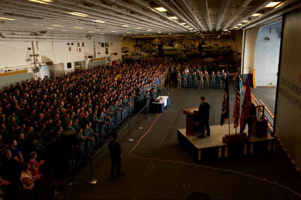 U.S. Navy Aviation Electronics Technician 1st Class Sean Broadhurst, at lectern, selected for promotion to chief petty officer, the master of ceremonies, delivers remarks as part of a 9-11 remembrance ceremony 140911-N-LQ799-083
