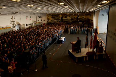 U.S. Navy Aviation Electronics Technician 1st Class Sean Broadhurst, at lectern, selected for promotion to chief petty officer, the master of ceremonies, delivers remarks as part of a 9-11 remembrance ceremony 140911-N-LQ799-083