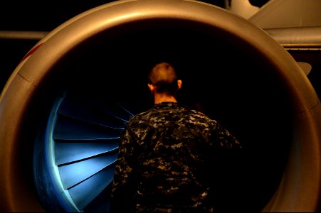 U.S. Navy Aviation Machinist's Mate 3rd Class Justin Kaiser, assigned to Patrol Squadron (VP) 16, uses a flashlight to check the structural integrity of a P-8A Poseidon aircraft before a mission to assist in sear 140401-N-VD564-018