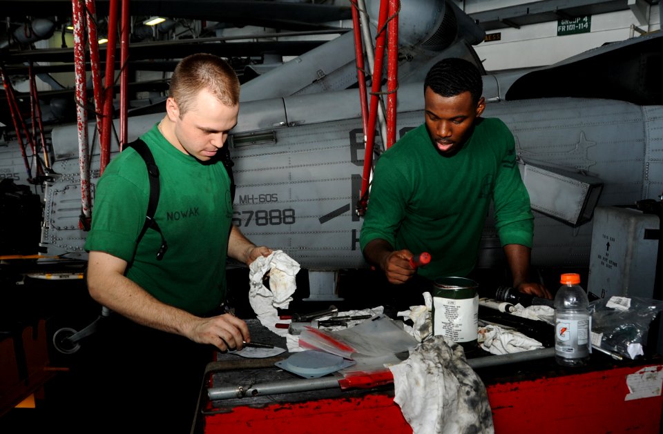 U.S. Navy Aviation Structural Mechanic 2nd Class Edward Nowak, left, and Aviation Structural Mechanic 2nd Class Gregory McDuffie clean tools for an MH-60S Seahawk helicopter assigned to Helicopter Sea Combat 140701-N-MU440-032