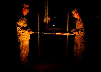 U.S. Navy Builder 1st Class Edward Krueger, left, and Logistics Specialist 1st Class Krystal Cicenas, both selected as chief petty officers, fold a ceremonial U.S. flag flown in remembrance of 9-11 at the New 140911-N-JP566-292