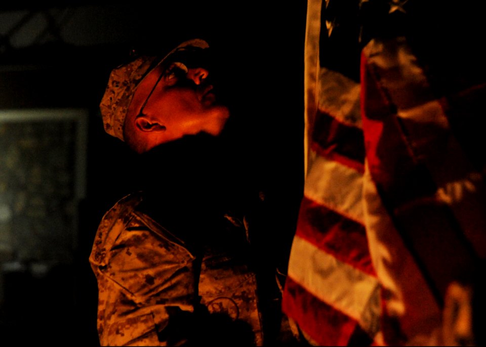 U.S. Navy Builder 1st Class John Armstrong, selected as a chief petty officer assigned to Naval Mobile Construction Battalion 25, raises a ceremonial U.S. flag flown in remembrance of 9-11 at the New Kabul 140911-N-JP566-255