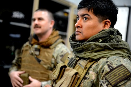 U.S. Navy Boatswain's Mate 1st Class Eddie Montalvo, right, and Electronics Technician 1st Class Garrett Swanson, both assigned to Commander, Task Force (CTF) 56, don body armor for weapons training at Naval 140212-N-OU681-220