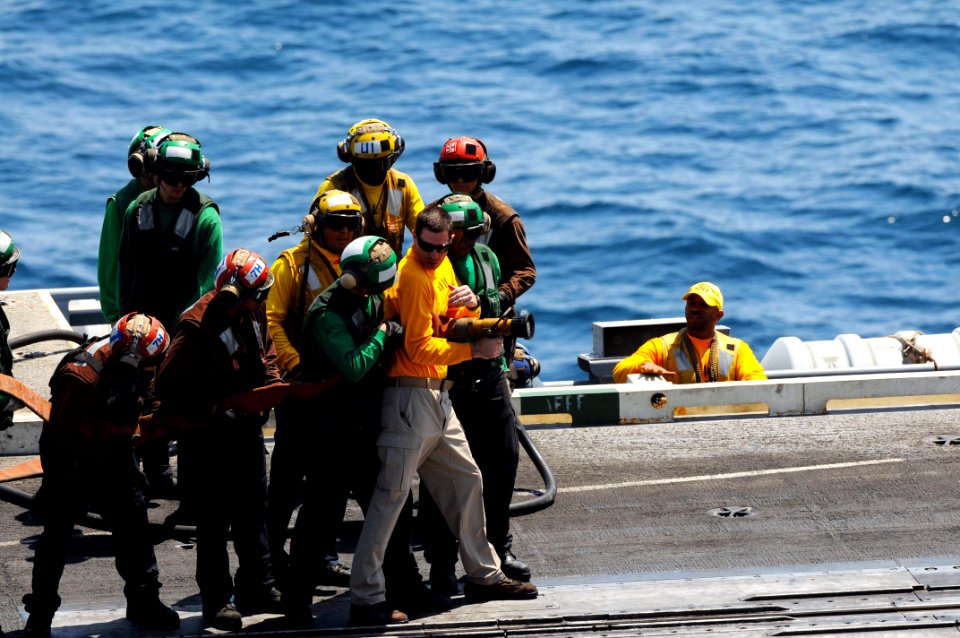U.S. Navy Chief Aviation Boatswain's Mate (Handling) Shawn Riley instructs Sailors on proper fire hose handling techniques June 27, 2014, during a general quarters drill on the flight deck of the aircraft 140627-N-CZ979-051