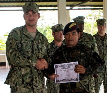 U.S. Navy Boatswain's Mate 3rd Class Zach Martin, left, attached to Coastal Riverine Squadron (CORIVRON) 2, gives a certificate to a Guatemalan service member as part of their closing ceremony in Puerto Barrios 140821-N-QY430-039
