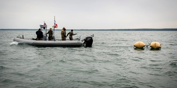 U.S. Navy and Estonia explosive ordnance disposal team members tow a World War II-era mine. (18163327428)