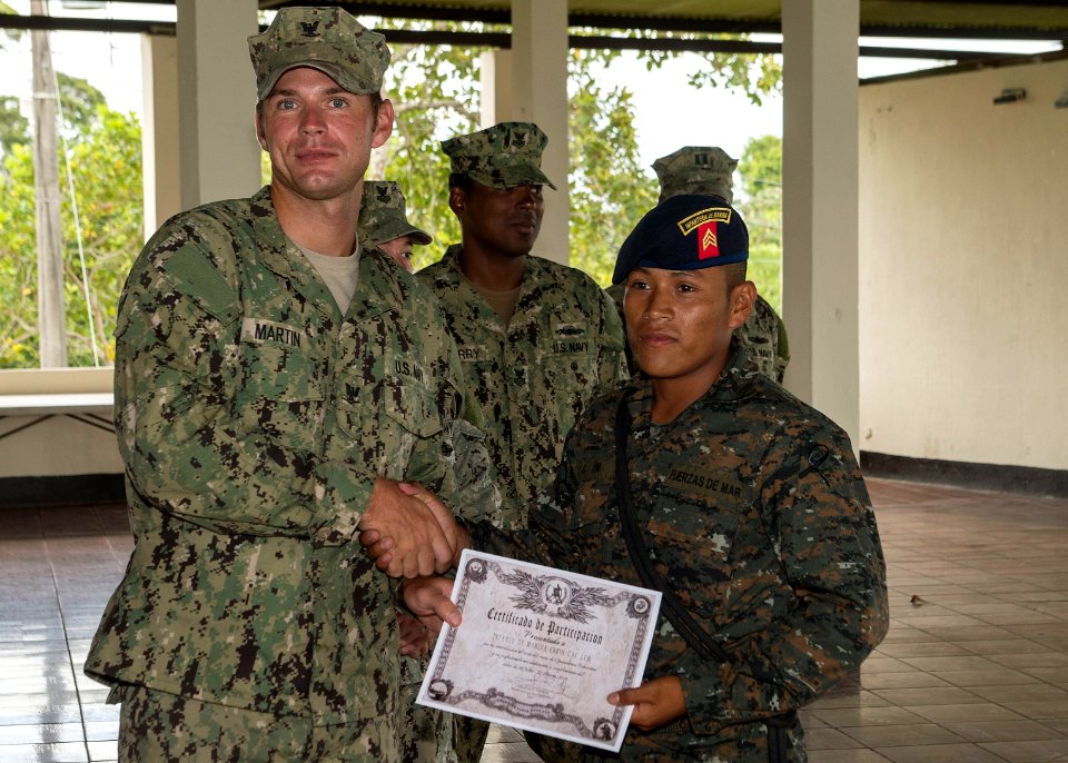 U.S. Navy Boatswain's Mate 3rd Class Zach Martin, left, attached to Coastal Riverine Squadron (CORIVRON) 2, gives a certificate to a Guatemalan service member as part of their closing ceremony in Puerto Barrios 140821-N-QY430-053