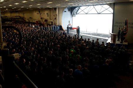 U.S. Navy chief petty officer selectees fold a U.S. flag as part of a 9-11 remembrance ceremony in the hangar bay of the newly commissioned amphibious assault ship USS America (LHA 6) Sept 140911-N-LQ799-174