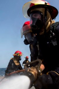 U.S. Sailors man a fire hose during a drill aboard the guided missile cruiser USS Philippine Sea (CG 58) in the Arabian Sea April 5, 2014 140405-N-PJ969-337 photo