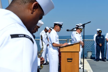 U.S. Navy Chief Logistics Specialist Rommel Langomez, at the lectern, gives a benediction aboard the guided missile destroyer USS Ross (DDG 71) in the Black Sea during a 9-11 remembrance ceremony Sept 140911-N-IY142-029