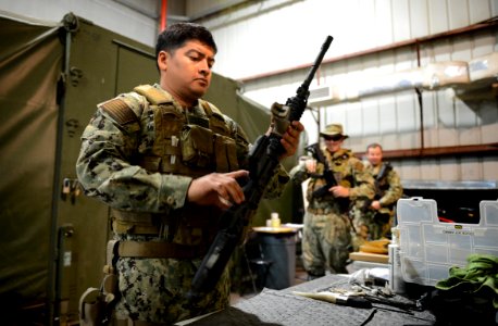 U.S. Navy Boatswain's Mate 1st Class Eddie Montalvo, left, assigned to Commander, Task Force (CTF) 56, reassembles an M4 carbine during weapons training at Naval Support Activity Bahrain in Manama, Bahrain 140212-N-OU681-214
