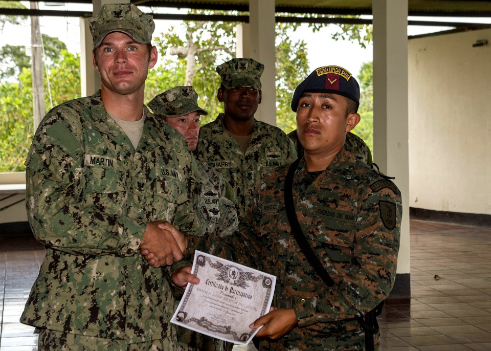 U.S. Navy Boatswain's Mate 3rd Class Zach Martin, attached to Coastal Riverine Squadron (CORIVRON) 2, gives a certificate to a Guatemalan service member as part of their closing ceremony in Puerto Barrios 140821-N-QY430-051
