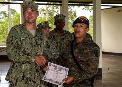 U.S. Navy Boatswain's Mate 3rd Class Zach Martin, attached to Coastal Riverine Squadron (CORIVRON) 2, gives a certificate to a Guatemalan service member as part of their closing ceremony in Puerto Barrios 140821-N-QY430-051
