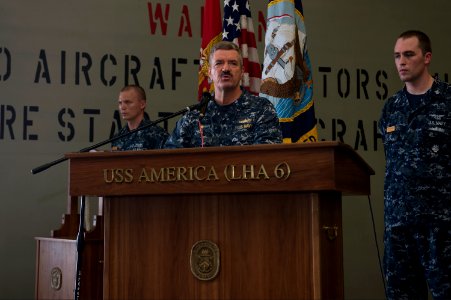 U.S. Navy Capt. Robert A. Hall Jr., center, the commanding officer of the newly commissioned amphibious assault ship USS America (LHA 6), gives opening remarks during a 9-11 remembrance ceremony in the ship's 140911-N-MD297-050