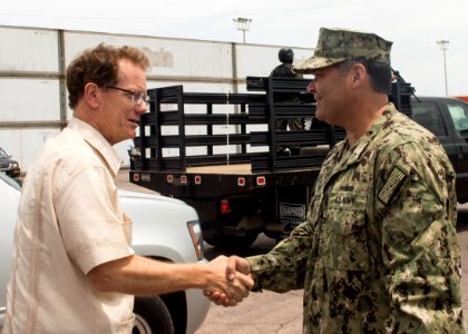 U.S. Navy Capt. Sam Hancock, right, the mission commander for Southern Partnership Station (SPS) 2014 operations aboard the joint high speed vessel USNS Spearhead (JHSV 1), exchanges greetings with U.S 140901-N-QY430-069