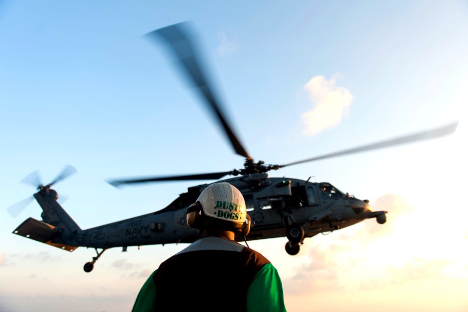 U.S. Navy Chief Aviation Structural Mechanic Brian Brooks, assigned to Helicopter Sea Combat Squadron (HSC) 7, watches an MH-60S Seahawk helicopter launch from the flight deck of the aircraft carrier USS Harry 140307-N-ZG705-035