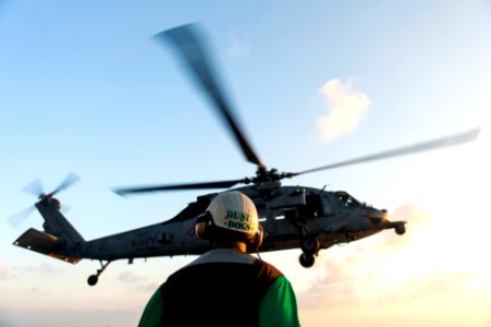 U.S. Navy Chief Aviation Structural Mechanic Brian Brooks, assigned to Helicopter Sea Combat Squadron (HSC) 7, watches an MH-60S Seahawk helicopter launch from the flight deck of the aircraft carrier USS Harry 140307-N-ZG705-035