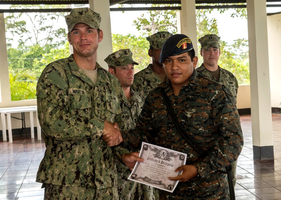 U.S. Navy Boatswain's Mate 3rd Class Zach Martin, left, attached to Coastal Riverine Squadron (CORIVRON) 2, gives a certificate to a Guatemalan service member as part of their closing ceremony in Puerto Barrios 140821-N-QY430-040