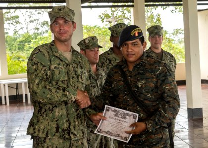 U.S. Navy Boatswain's Mate 3rd Class Zach Martin, left, attached to Coastal Riverine Squadron (CORIVRON) 2, gives a certificate to a Guatemalan service member as part of their closing ceremony in Puerto Barrios 140821-N-QY430-040