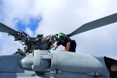 U.S. Navy Aviation Electronics Technician 3rd Class Austin Luna conducts maintenance on an MH-60R Seahawk helicopter on the guided missile destroyer USS Kidd (DDG 100) in the Indian Ocean March 16, 2014 140316-N-ZZ999-001