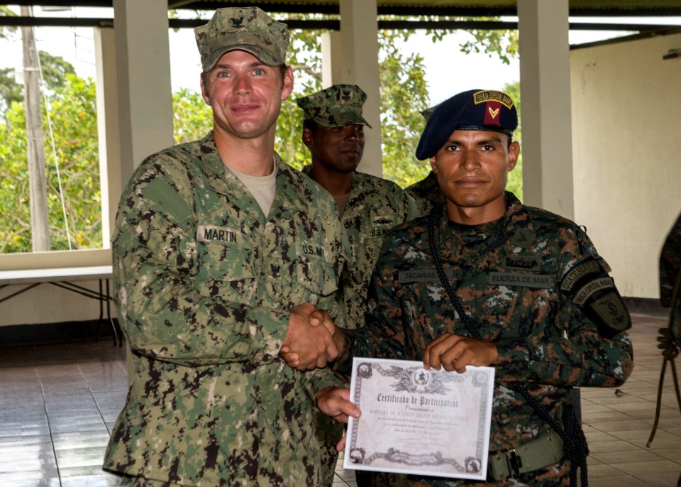 U.S. Navy Boatswain's Mate 3rd Class Zach Martin, left, attached to Coastal Riverine Squadron (CORIVRON) 2, gives a certificate to a Guatemalan service member as part of their closing ceremony in Puerto Barrios 140821-N-QY430-083