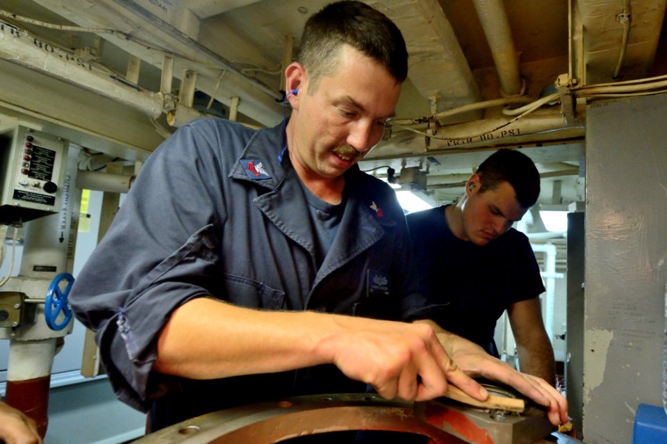 U.S. Navy Engineman 1st Class Shawn Heaton cleans a fire pump seal fitting aboard the guided missile destroyer USS Ross (DDG 71) Aug. 25, 2014, at Naval Support Activity Souda Bay, Greece 140825-N-IY142-385