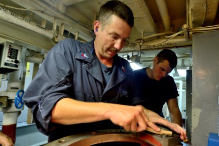 U.S. Navy Engineman 1st Class Shawn Heaton cleans a fire pump seal fitting aboard the guided missile destroyer USS Ross (DDG 71) Aug. 25, 2014, at Naval Support Activity Souda Bay, Greece 140825-N-IY142-385