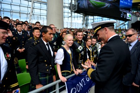 U.S. Navy Chief of Naval Operations Adm. Jonathan Greenert, second from right, receives a challenge coin from a U.S. Naval Academy midshipman during the University of Notre Dame versus Navy Midshipmen NCAA 120901-N-WL435-637